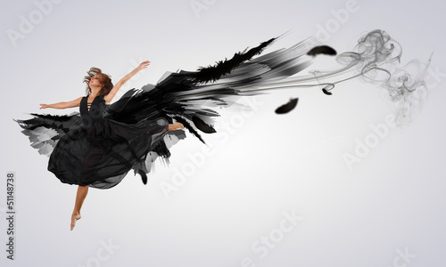 Photo: Woman floating on dark wings Woman floating on dark wings