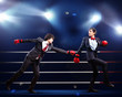 Two young businessman boxing