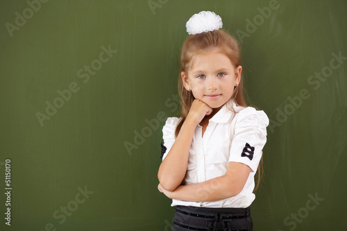 Photo: Scoolgirl standing near blackboard Scoolgirl standing near blackboard