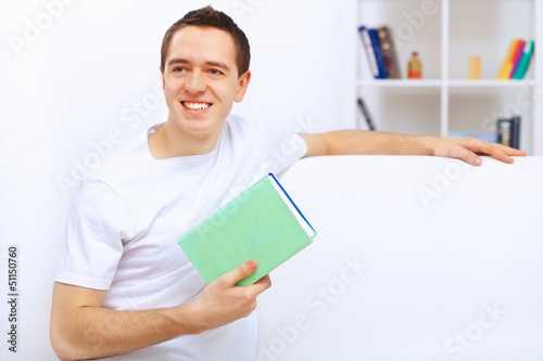 Photo: Young man at home with a book Young man at home with a book