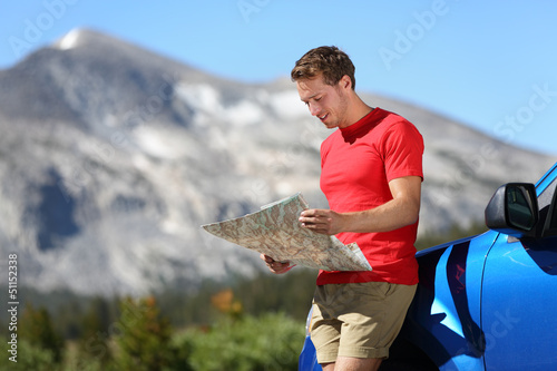 Photo: Driver man looking at map by car in Yosemite Park Driver man looking at map by car in Yosemite Park