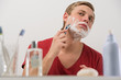 Young man shaving at home
