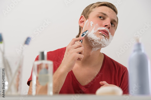 Photo: Young man shaving at home Young man shaving at home