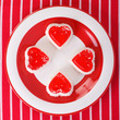 cheesecakes in  heart on a striped tablecloth. top view