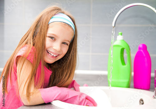 Photo: Little girl washing the dishes Little girl washing the dishes
