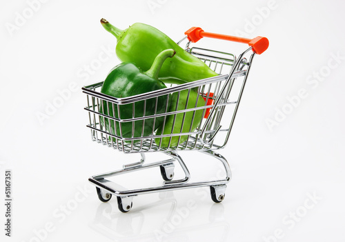 Photo: Green sweet pepper paprika in shopping trolley on white backgro Green sweet pepper paprika in shopping trolley on white backgro