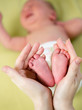 mother hands holding small baby's feet