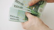 hands counting 100 euro money notes