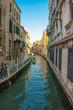 Converging view of Venice buildings along the canal and walkway