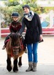 Mother riding her son on a pony 