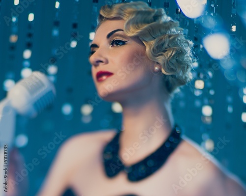Photo: Elegant blond retro woman singer with beautiful hairdo Elegant blond retro woman singer with beautiful hairdo