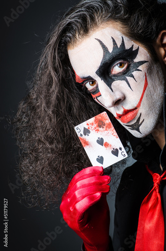 Photo: Evil clown with cards in dark room Evil clown with cards in dark room