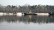 Old tugboat pulling a cargo barge on the wide fast river