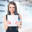 Businesswoman in front of office building holding tablet