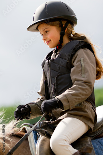 Photo: Horse riding - lovely girl is riding on a horse Horse riding - lovely girl is riding on a horse