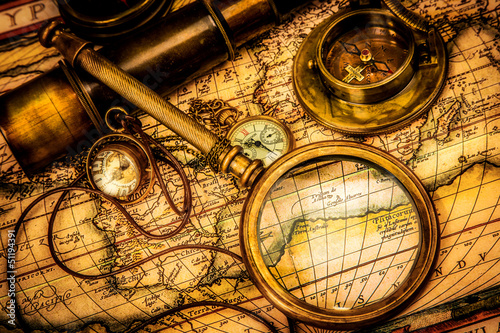 Photo: Vintage magnifying glass lies on an ancient world map Vintage magnifying glass lies on an ancient world map