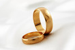 Golden wedding rings on white silk