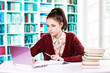 Pretty young college student in a library