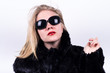 upper class girl in dark sunglasses, red lipstick and fur