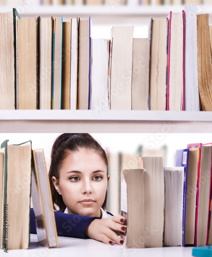 Photo: Pretty young college student in a library Pretty young college student in a library