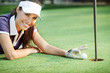 Happy woman golf  pushing golf ball into the hole