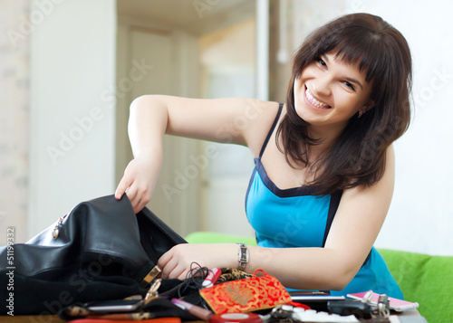 Photo: positive woman finding anything in purse positive woman finding anything in purse