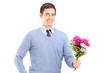 A young romantic man holding a bouquet of flowers
