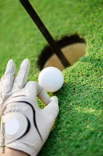 Photo: pushing golf ball into the hole pushing golf ball into the hole