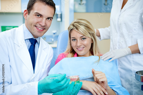 Photo: dentist explaining a female patient denture work dentist explaining a female patient denture work