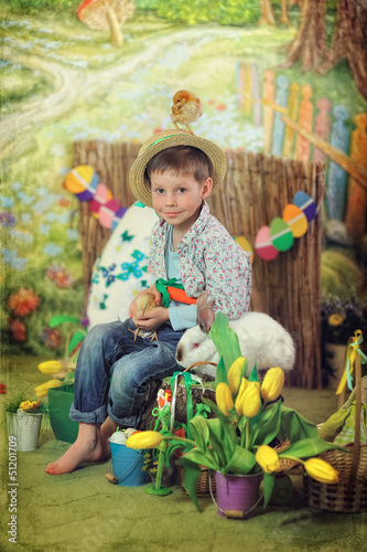 Photo: Easter theme with small boy with toy bunnies, chicks and eggs Easter theme with small boy with toy bunnies, chicks and eggs