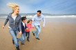 Family running on the beach