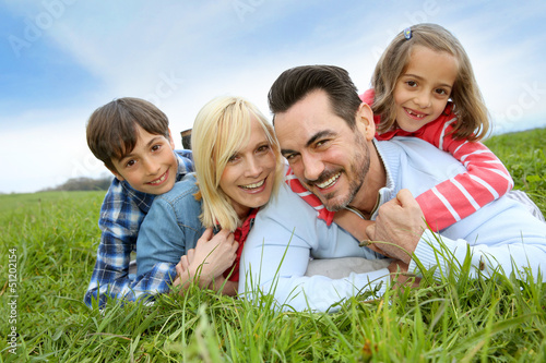 Photo: Family of four relaxing in countryside Family of four relaxing in countryside