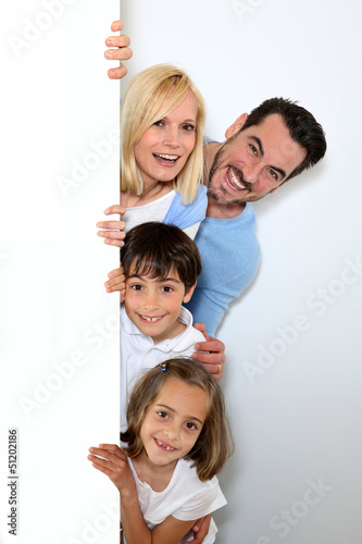 Photo: Family hiding behind message board Family hiding behind message board
