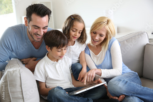 Photo: Family websurfing on internet with tablet Family websurfing on internet with tablet