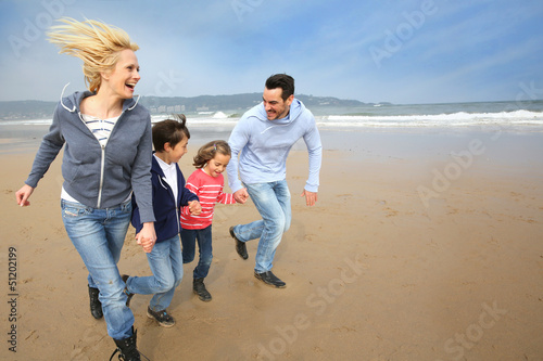 Photo: Family running on the beach Family running on the beach