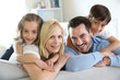 Family of four sitting in sofa at home