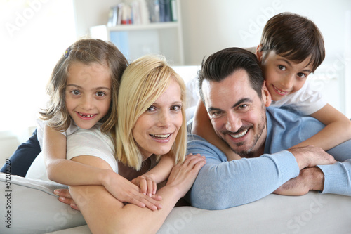 Photo: Family of four sitting in sofa at home Family of four sitting in sofa at home