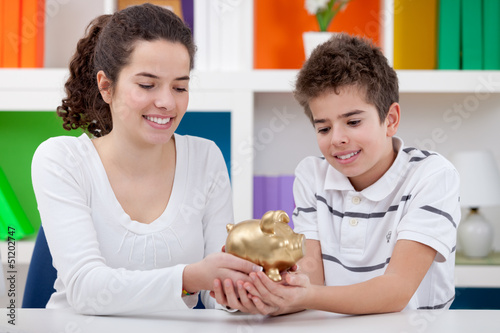 Photo: Two children holding piggybank Two children holding piggybank