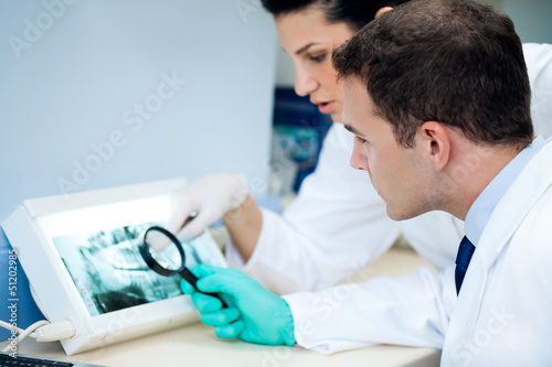 Photo: Team dentist analyzing x-ray. Team dentist analyzing x-ray.