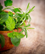 Mortar with herbs on wooden table