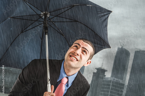 Photo: Businessman under heavy rain Businessman under heavy rain