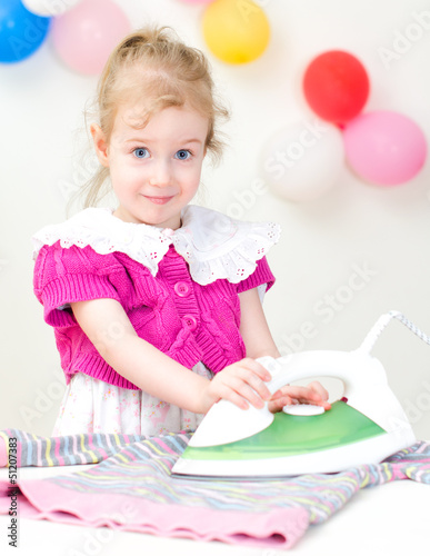 Photo: Cute little girl ironing clothes Cute little girl ironing clothes