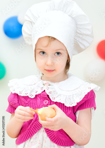 Photo: Little girl in chief hat cooking dinner Little girl in chief hat cooking dinner