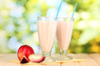 Foto: Peach milk shakes on wooden table on bright background Peach milk shakes on wooden table on bright background