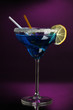 Blue cocktail in glass on color background
