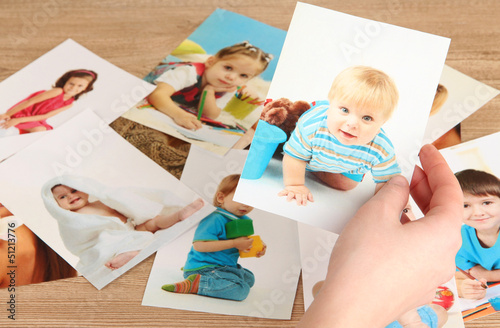 Photo: Photos in hands on wooden table Photos in hands on wooden table