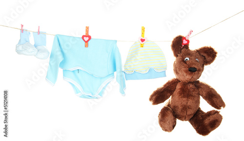 Photo: Baby clothes hanging on clothesline, isolated on white Baby clothes hanging on clothesline, isolated on white