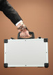 Hand with handcuff and suitcase, on color background