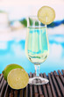 Green cocktail with lime on table on bright background