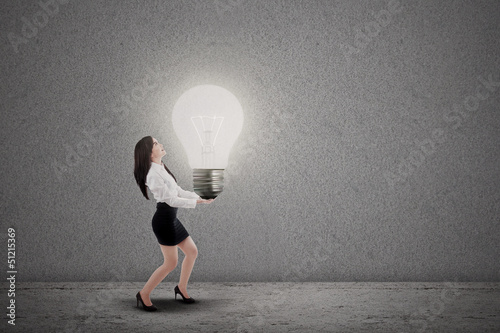 Photo: Asian businesswoman carry light bulb Asian businesswoman carry light bulb